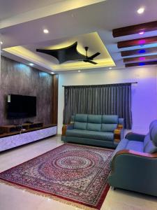 a living room with a couch and a flat screen tv at Marvee Luxus Stay in Coimbatore