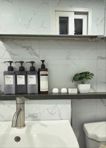 La salle de bains est pourvue d'un lavabo et d'une étagère avec des bouteilles. dans l'établissement 달빛그리기Moonlight, à Daegu