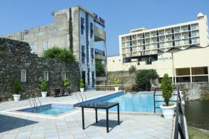 a hotel pool with a table in front of a building at Hotel Rangbhawan Kumbhalgarh in Kelwāra