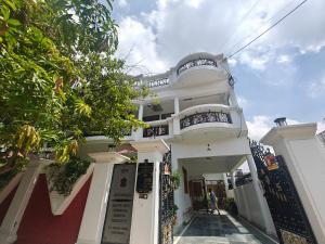 een wit gebouw met een trap ervoor bij Homestay - Serviced Apartment "ISH Atithya" with Modular Kitchen, various amenities and Complimentary Breakfast in Lucknow, IN in Lucknow