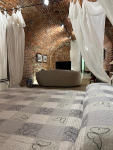 a room with two beds and a bath tub in it at Taverna La Torre in Bassano del Grappa