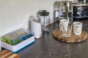 维克多港K Rose Cottage In the heart of Victor Harbor - No Linen Included的柜台上放着两台咖啡机和一个装有杯子的托盘。 更多27张照片