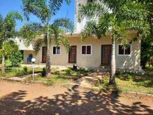 een gebouw met palmbomen ervoor bij Holidaypark in Araku