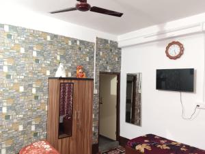 a living room with a ceiling fan and a tv at Mountain Retreat Ecostay in Kalimpong