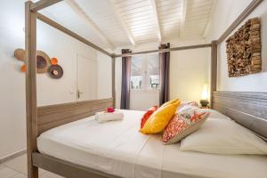 - une chambre avec un lit à baldaquin et des oreillers dans l'établissement OFFRE NOËL ! CASA LYDIE Évasion créole avec piscine, à Saint-François