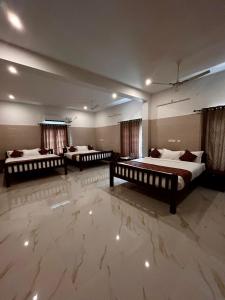 three beds in a room with marble floors at Luxus Resort in Puducherry