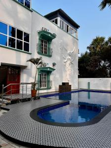 a house with a swimming pool in front of a building at Luxus Resort in Puducherry