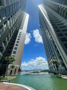 zwei hohe Gebäude mit einem Wasserbecken dazwischen in der Unterkunft Nhà của Bi in Hạ Long