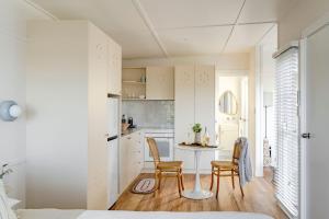 a small kitchen and dining room with a table and chairs at The Bunkie @ Ethel & Odes in Bundeena