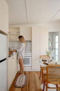 a woman standing in a kitchen preparing food at The Bunkie @ Ethel & Odes in Bundeena