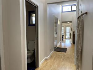 un couloir avec une salle de bain avec WC et une fenêtre dans l'établissement The Songbird, à Evergreen 28 autres photos