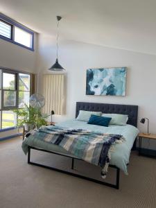 une chambre avec un lit et un tableau au mur dans l'établissement The Songbird, à Evergreen