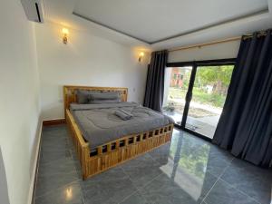 Phumĭ Kâoh RŏngにあるKoh Rong Lagoonの大きな窓のある部屋のベッド