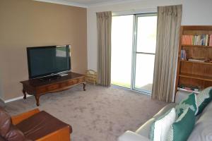 un salon avec une télévision à écran plat et un canapé dans l'établissement Tranquil Beach Escape, à Evergreen