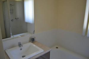 une salle de bain blanche avec un lavabo et une baignoire dans l'établissement Tranquil Beach Escape, à Evergreen 5 autres photos