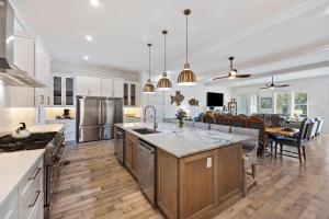 a kitchen with white cabinets and a dining room at PALM2905: 2905 Palm Blvd. in Isle of Palms