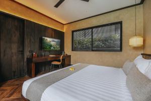 een slaapkamer met een groot bed en een bureau bij Le Cielo Resort Canggu Batu Bolong by Maviba in Canggu