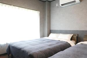 a bedroom with two beds and a window at Kiwaya 貴和家 - Fuji Numazu BASE - in Numazu