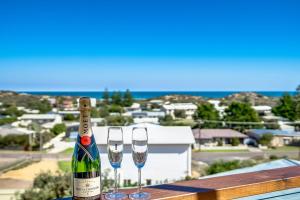 a bottle of wine and two glasses on a table at SEASCAPE - Pet Friendly Linen Included - 65 Corcoran in Goolwa South