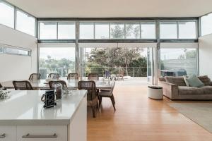 a kitchen and living room with a table and chairs at Wattle Seed Beach House in Evergreen