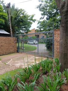 a metal gate in a yard with a driveway at Net 'n Bed in Middelburg