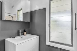 a bathroom with a white sink and a mirror at Murrah Street, 40 in Bermagui +8 photos