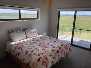 a bedroom with a bed and a view of a field at Ngurra in Evergreen