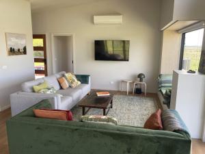 a living room with a green couch and a table at Ngurra in Evergreen