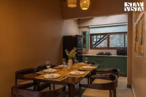 - une salle à manger avec une table, des chaises et des verres à vin dans l'établissement StayVista at Avasa Stays with Views, Jacuzzi, Meals, à Nainital