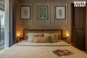 une chambre avec un lit avec trois tableaux au mur dans l'établissement StayVista at Avasa Stays with Views, Jacuzzi, Meals, à Nainital