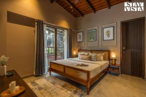 une chambre avec un lit et une grande fenêtre dans l'établissement StayVista at Avasa Stays with Views, Jacuzzi, Meals, à Nainital