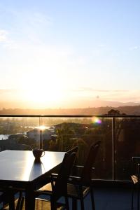 una mesa y sillas en un balcón con vistas a la puesta de sol en Tamar Views, en Inveresk