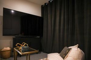 Una sala de estar con una cortina negra y un sofá. en Tamar Views, en Inveresk