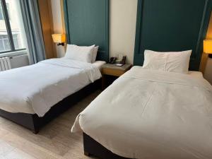 een hotelkamer met 2 bedden en een telefoon bij Ward Hotel Jinan Harmony Plaza Qilu Children's Hospital Branch in Jinan