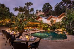 a restaurant with tables and chairs next to a pool at Hemingways Retreat Kigali in Kigali