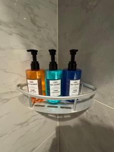 een plank met vier flessen odorizers aan de muur bij Ward Hotel Jinan Harmony Plaza Qilu Children's Hospital Branch in Jinan