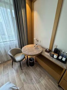 een kamer met een tafel, een stoel en een spiegel bij Ward Hotel Jinan Harmony Plaza Qilu Children's Hospital Branch in Jinan
