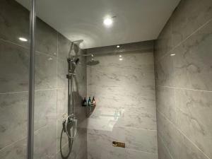 een badkamer met een douche met een glazen deur bij Ward Hotel Jinan Harmony Plaza Qilu Children's Hospital Branch in Jinan