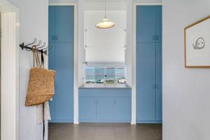 a hallway with blue cabinets and a window at 115 Seagull - Beachfront - Wi-Fi - No Linen Included in Hayborough