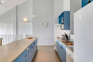 a kitchen with blue cabinets and a counter top at 115 Seagull - Beachfront - Wi-Fi - No Linen Included in Hayborough