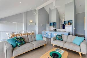 a living room with two couches and a kitchen at 115 Seagull - Beachfront - Wi-Fi - No Linen Included in Hayborough +17 photos