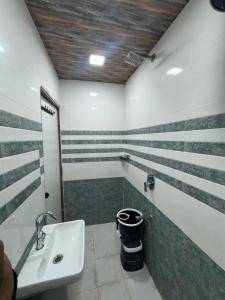 a bathroom with stripes on the walls and a sink at Baghdad Palace Near Dargah sharif in Ajmer