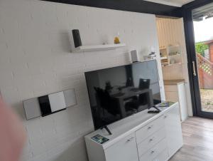 a living room with a large flat screen tv on a wall at Ferienhaus LouJa in Butjadingen