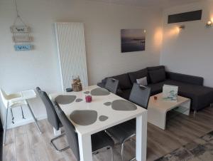 a living room with a white table and a couch at Ferienhaus LouJa in Butjadingen