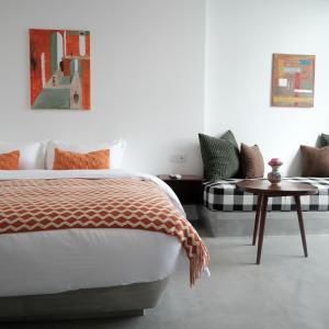 a bedroom with a bed and a couch and a table at Serenity Angkor in Phum Pobos