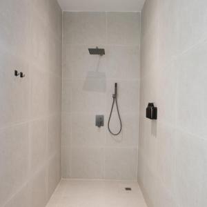 a white bathroom with a shower with a shower head at Serenity Angkor in Phum Pobos
