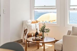 a living room with a table and a window with an umbrella at Fogo @ Ethel & Ode’s in Bundeena