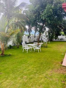 un grupo de sillas blancas y una mesa en el césped en Spring View Holiday Home - Villa, en Badulla