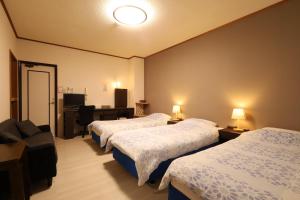 a hotel room with three beds and a couch at ペンション星砂 in Zamami