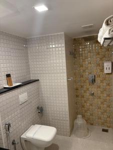 a bathroom with a toilet and a shower at Hotel Mangala Temple View in Guruvāyūr